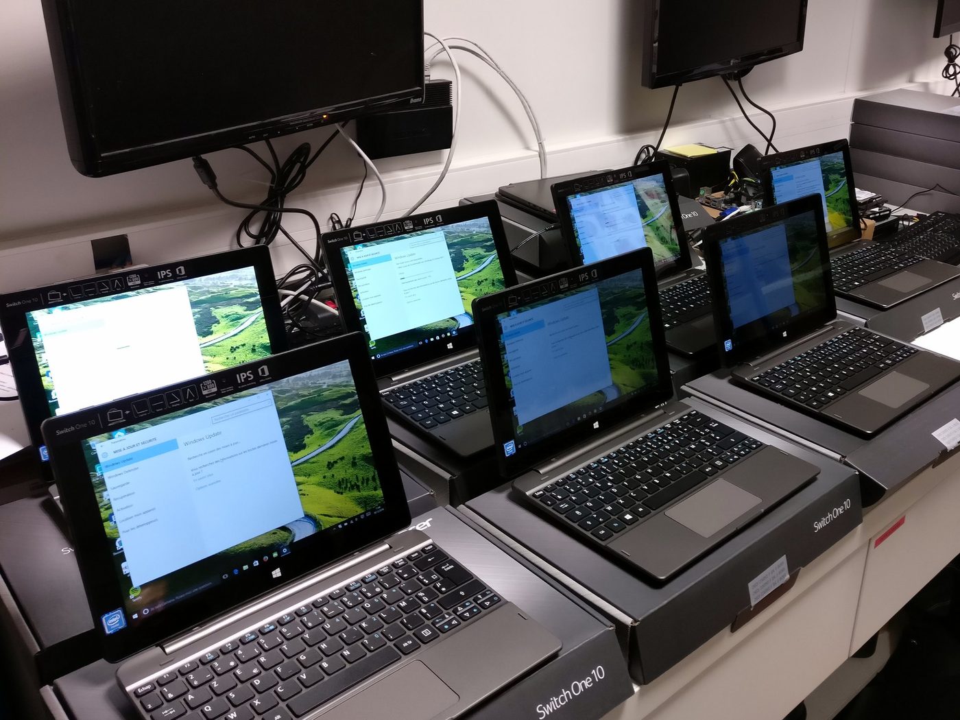 Une rangée d’ordinateurs portables en cours de préparation sur un établi.